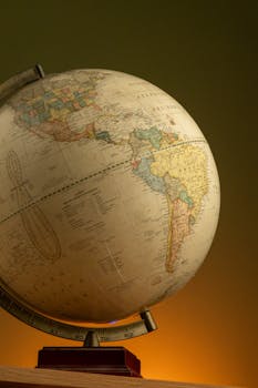 An antique globe showcasing detailed maps of North and South America with warm lighting.